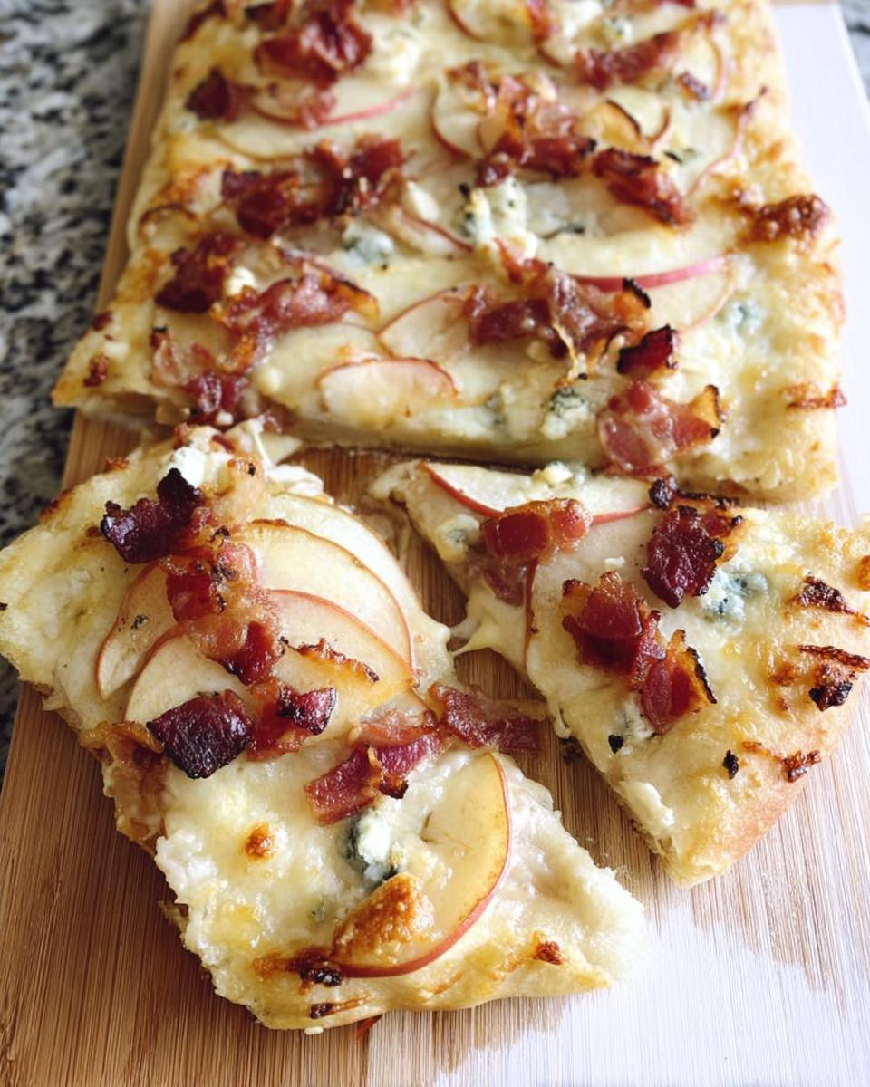 Close-up of a 10-ingredient pizza topped with thinly sliced apples, crispy bacon, and blue cheese.