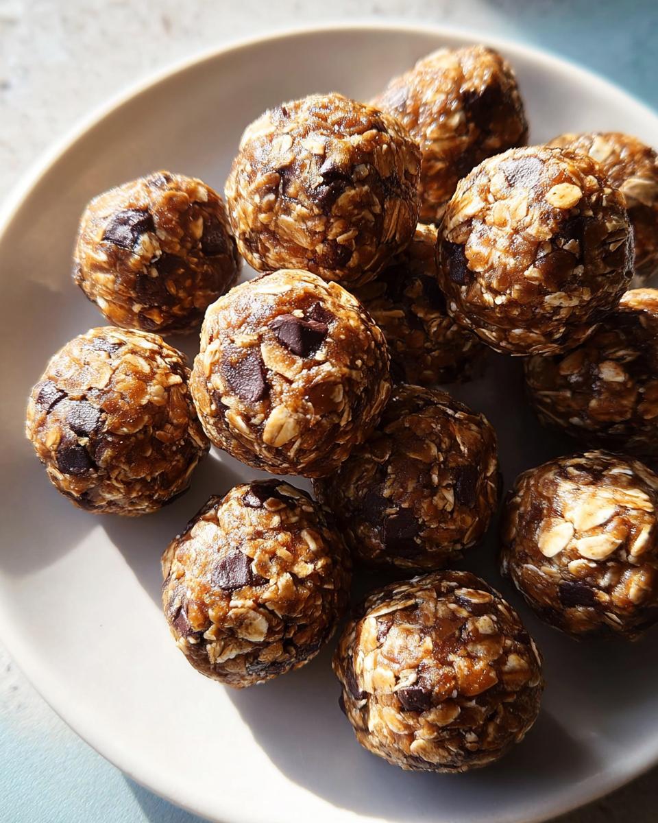 Close-up of chocolate chip energy balls, a healthy breakfast idea, on a white plate.