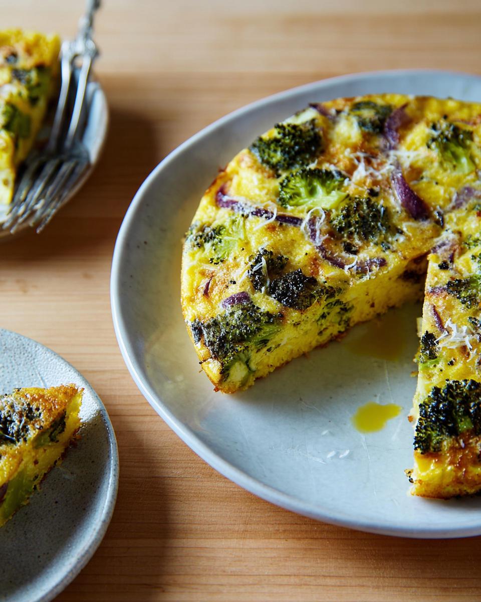 A slice of broccoli and red onion frittata, a delicious egg recipe, served on a plate.