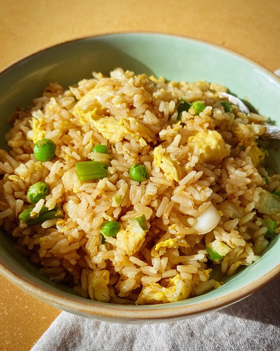 A bowl of delicious egg fried rice with peas and scallions, a perfect example of 7-Ingredient Egg Recipes.