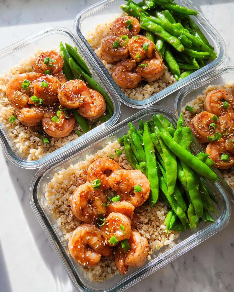 Four glass meal prep containers filled with brown rice, glazed shrimp, and green beans, perfect for shrimp recipes meal prep.