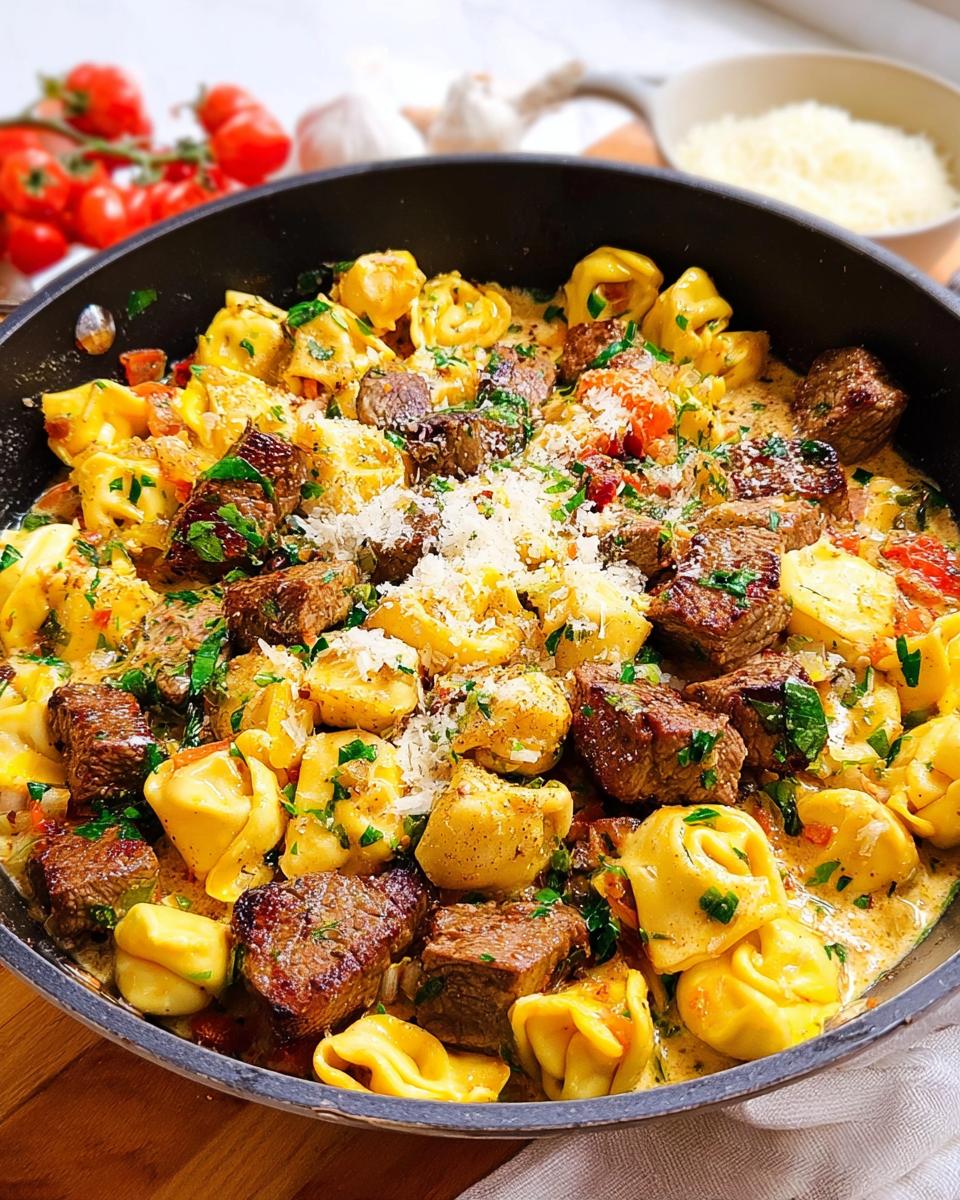 Close-up of Garlic Steak Tortellini in a creamy sauce, garnished with parsley and grated cheese.