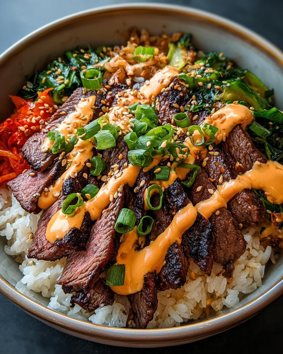 Close-up of Korean BBQ Steak Rice Bowls topped with spicy cream sauce, sesame seeds, and green onions.