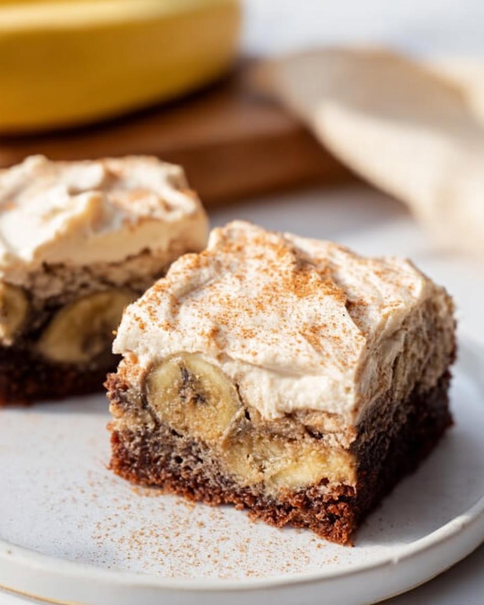 Two slices of Banana Bread Brownies Made Easy, topped with frosting and cinnamon.