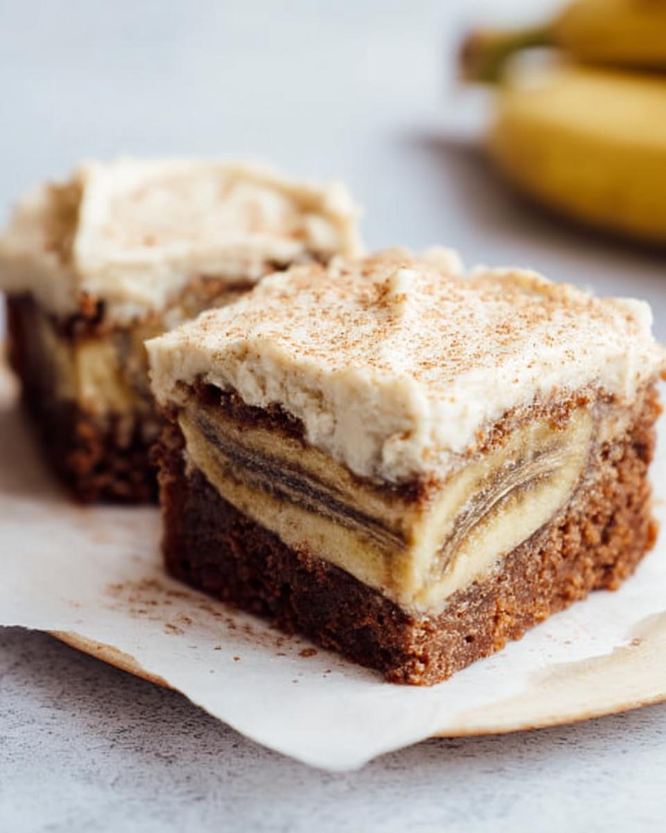 Two slices of Banana Bread Brownies Made Easy, topped with creamy frosting and cinnamon.