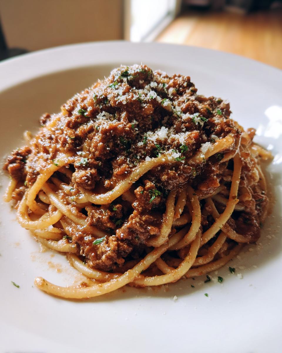 A close-up of a plate of Creamy High Protein Beef Pasta, topped with grated cheese and parsley.